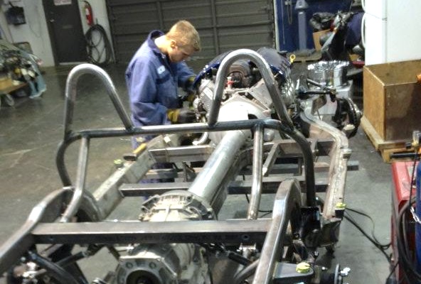 Chad working solo on a custom car chassis in the shop